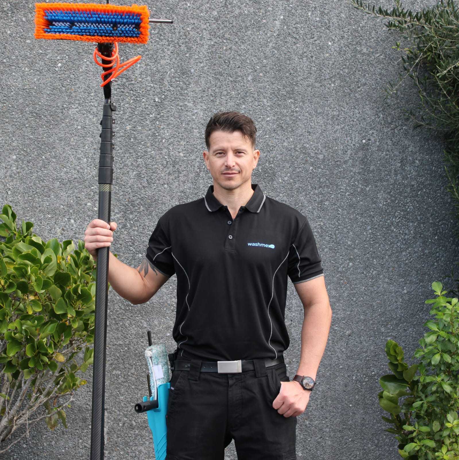 Dave standing with a wash brush outside of a commercial property